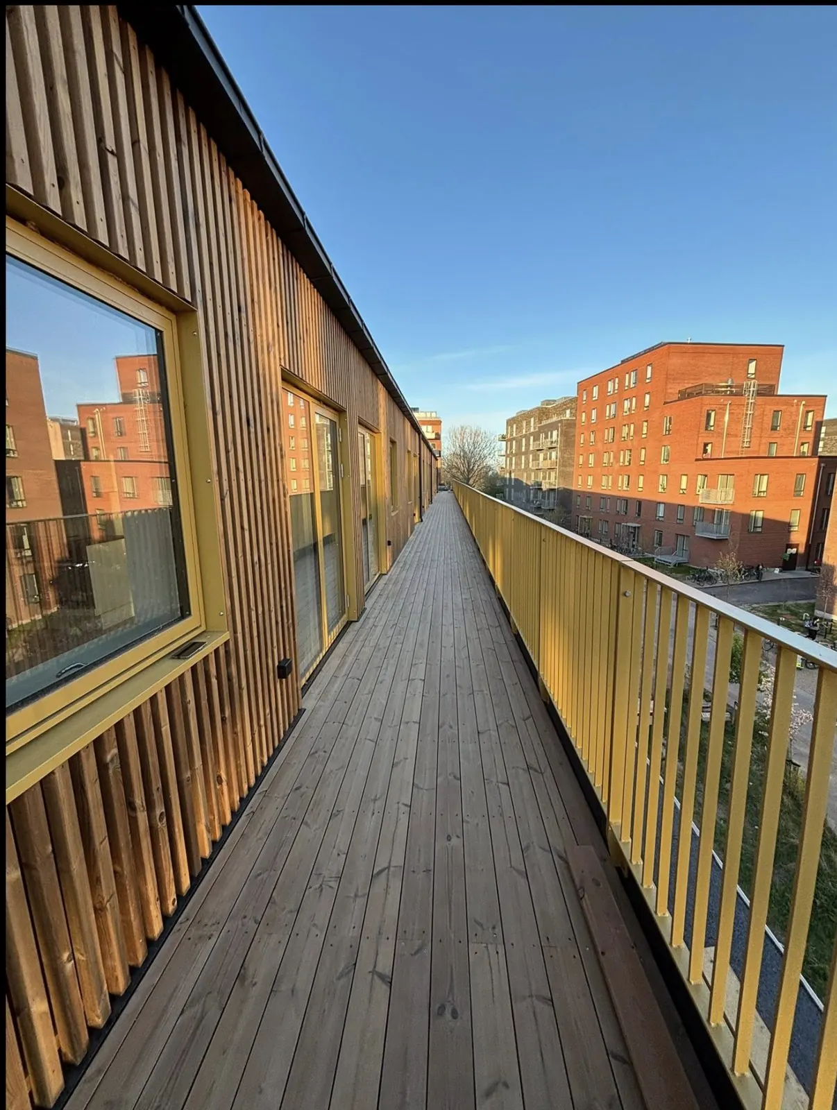 Altangang med terrassebrædder og facade i Thermo Fyr i København